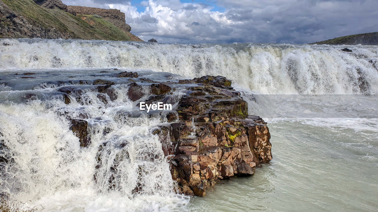 Scenic view of waterfall against sky