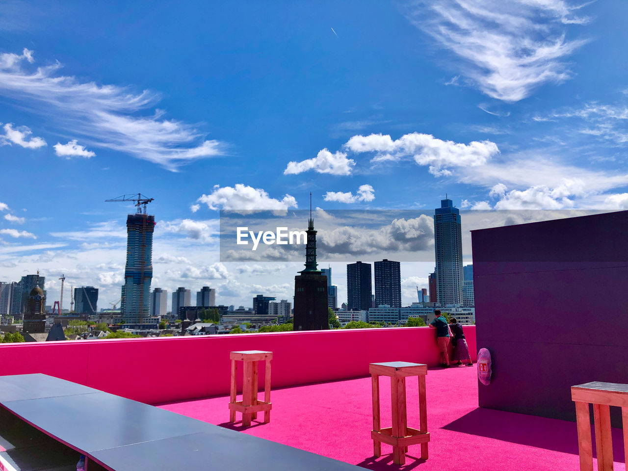 View at city center from a very pink platform on a roof under blue sky with white clouds