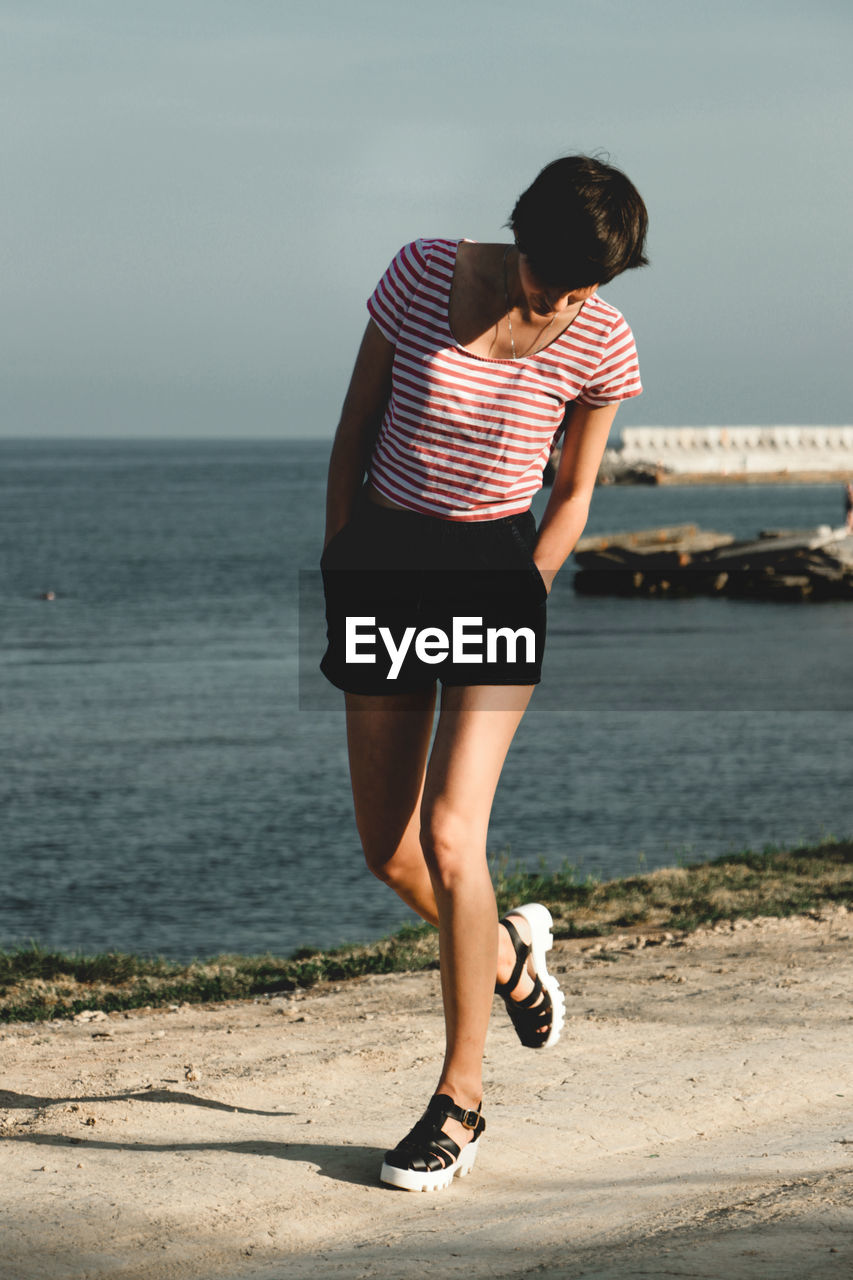 Full length of woman walking by sea