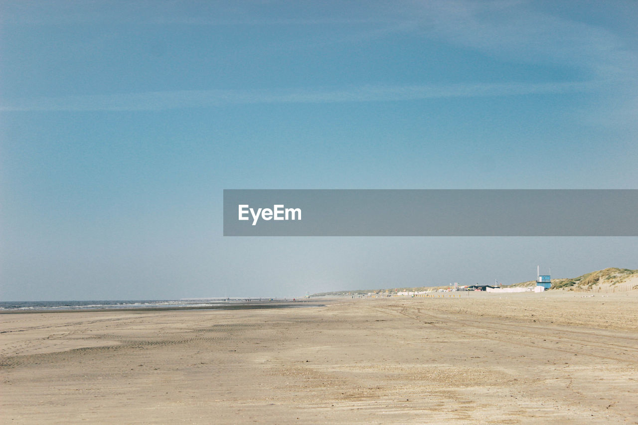 Scenic view of beach against clear blue sky