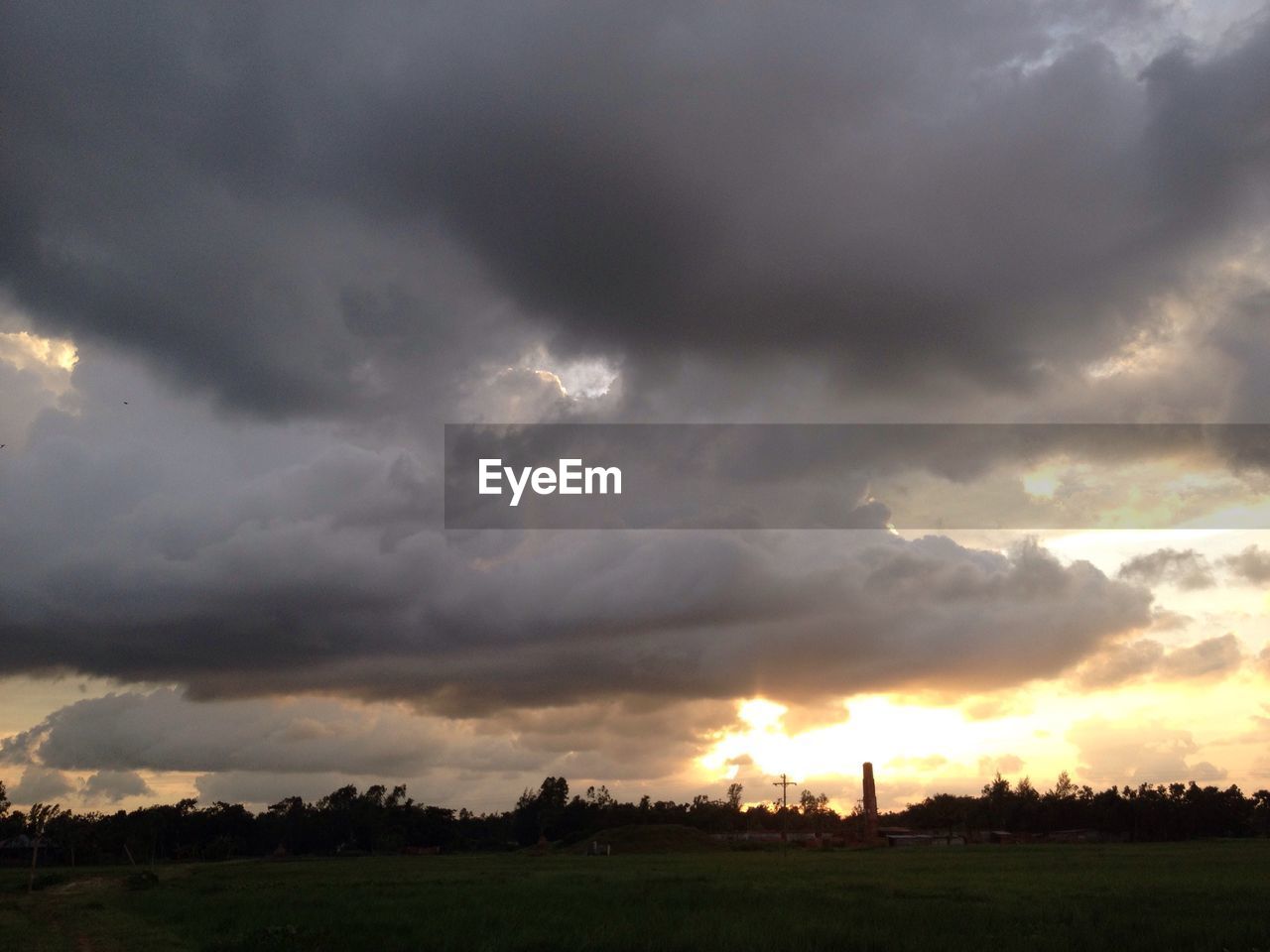 SCENIC VIEW OF STORM CLOUDS OVER FIELD