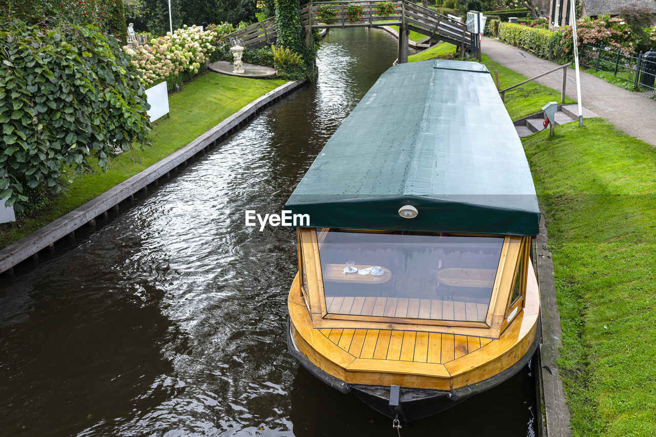 A wooden excursion boat moored in the channel, visible stern of the ship.