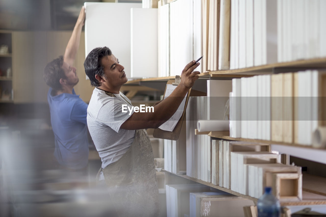 Man counting stock in canvas workshop