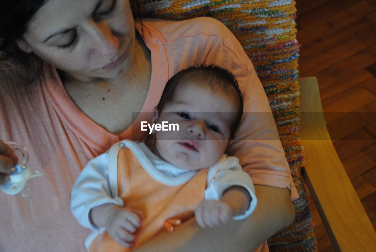 High angle view of mother sitting with toddler son on chair