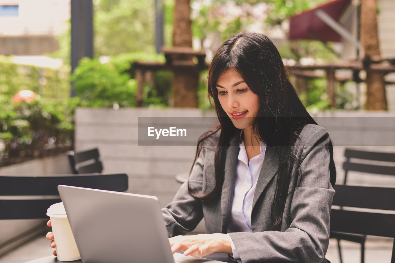 Businesswoman using laptop in cafe