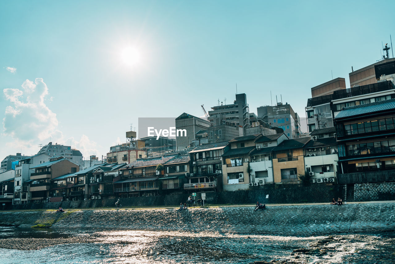 RIVER AMIDST BUILDINGS AGAINST SKY IN CITY