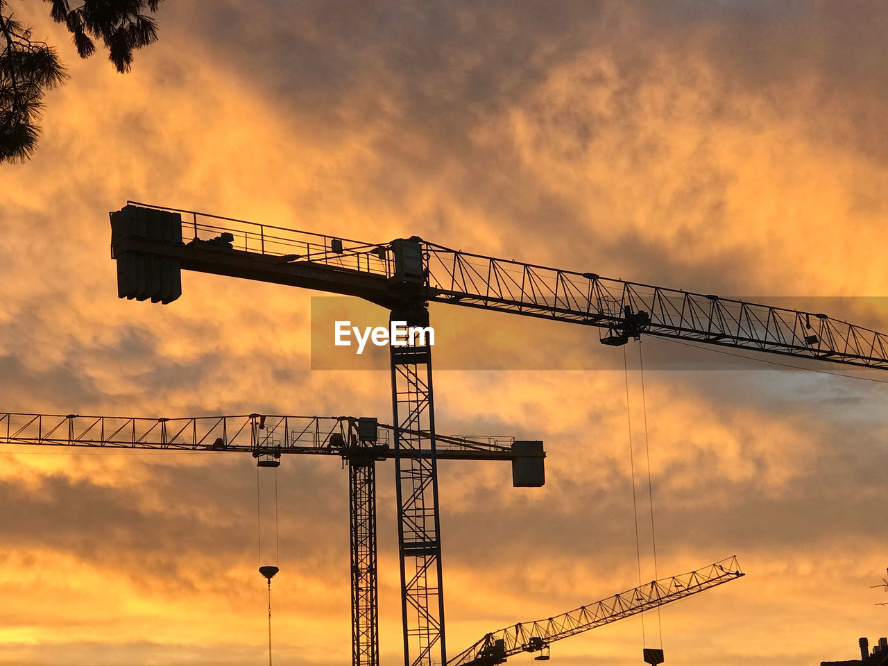 sky, sunset, machinery, crane - construction machinery, construction industry, cloud, silhouette, industry, nature, development, architecture, construction site, no people, outdoors, evening, business, metal, construction machinery, city, dusk, built structure, back lit, electricity, orange color, low angle view, sign, overhead power line, sunlight, business finance and industry, communication