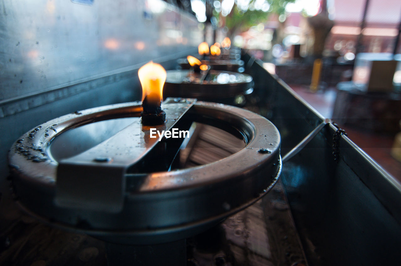 CLOSE-UP OF LIT TEA CANDLES IN TEMPLE