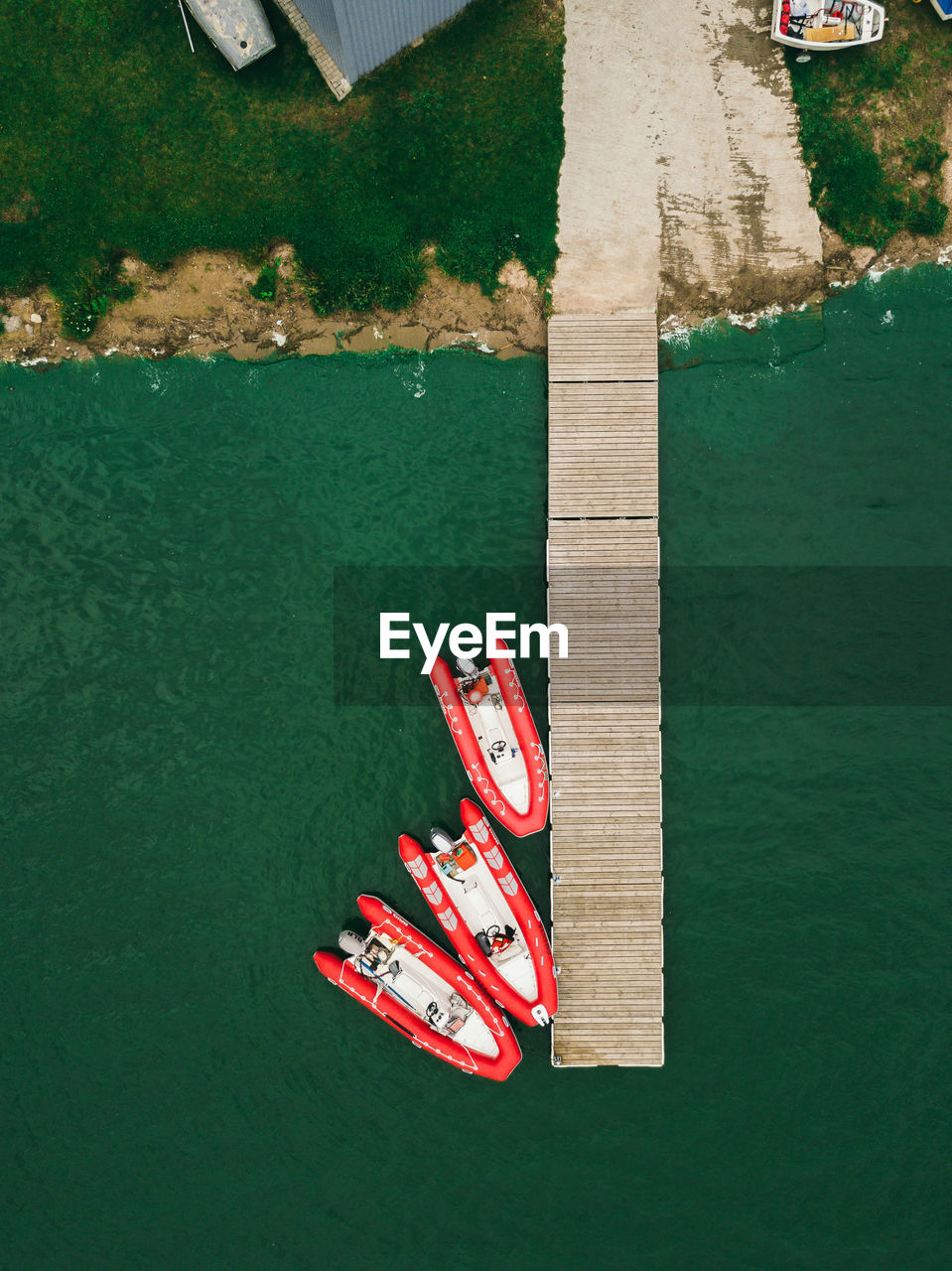 Red inflatable boats stand near the pier.aerial view by drone.
