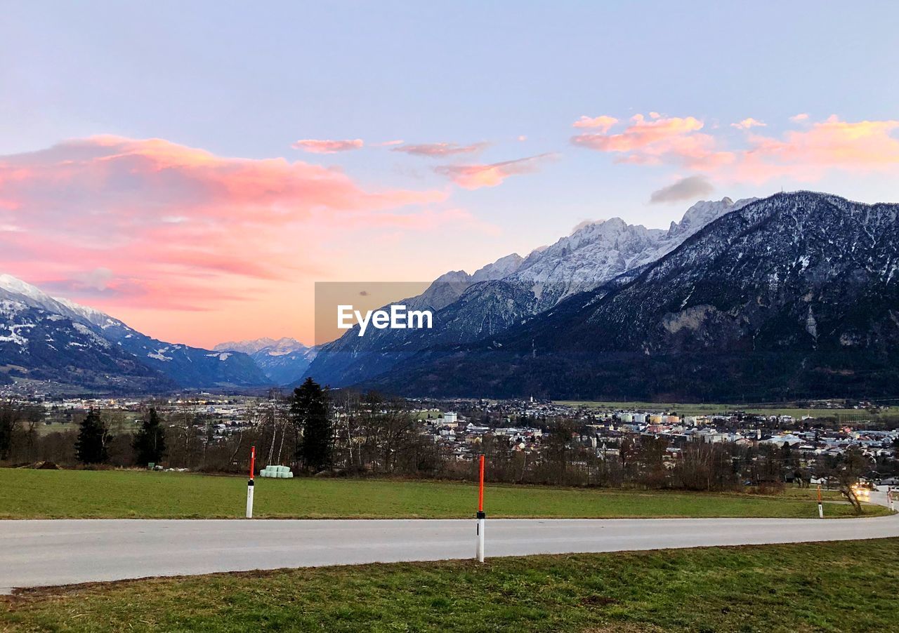 Scenic view of field and mountains against sky during sunset