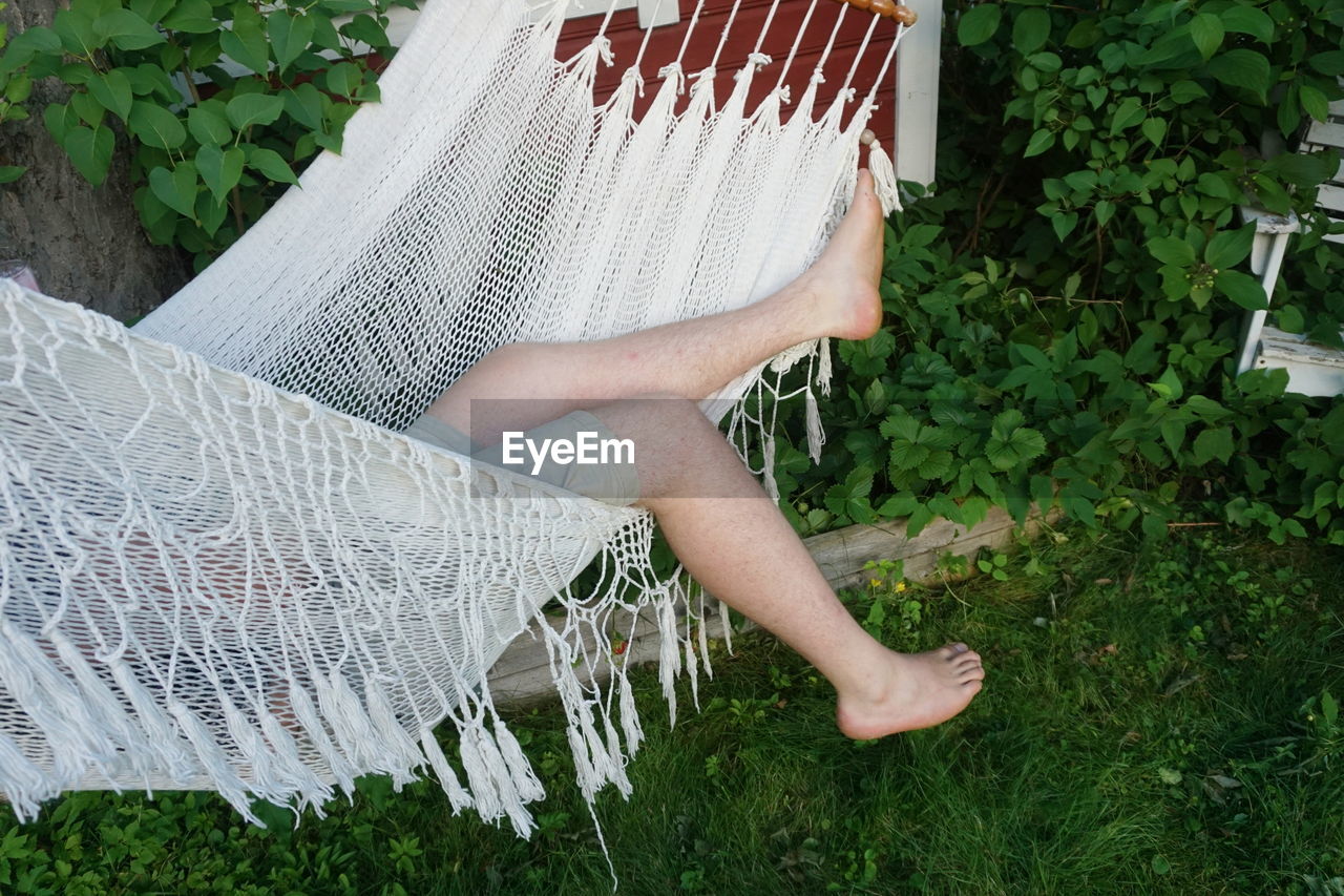 Low section of man sleeping in hammock