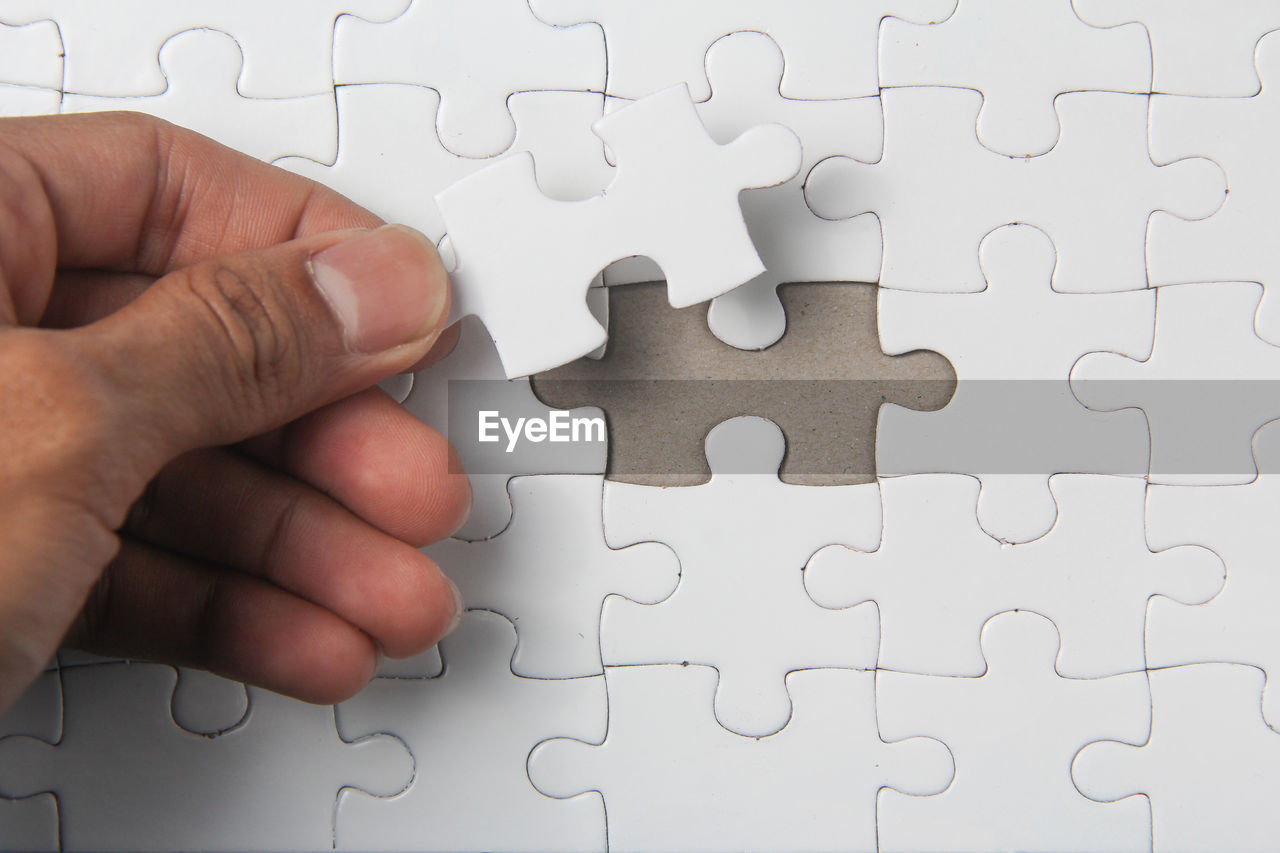 Close-up of human hand holding puzzle 