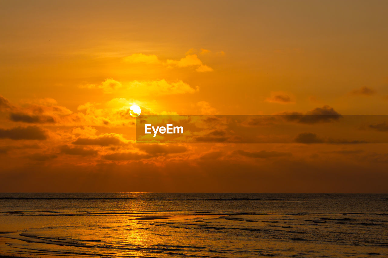 Dramatic evening sunset landscape view of bright orange twilight sky and sea