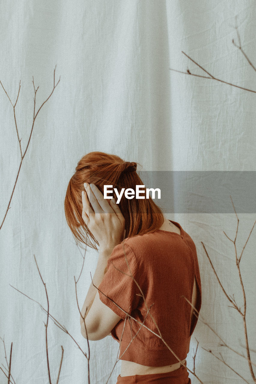 Rear view of woman standing against wall