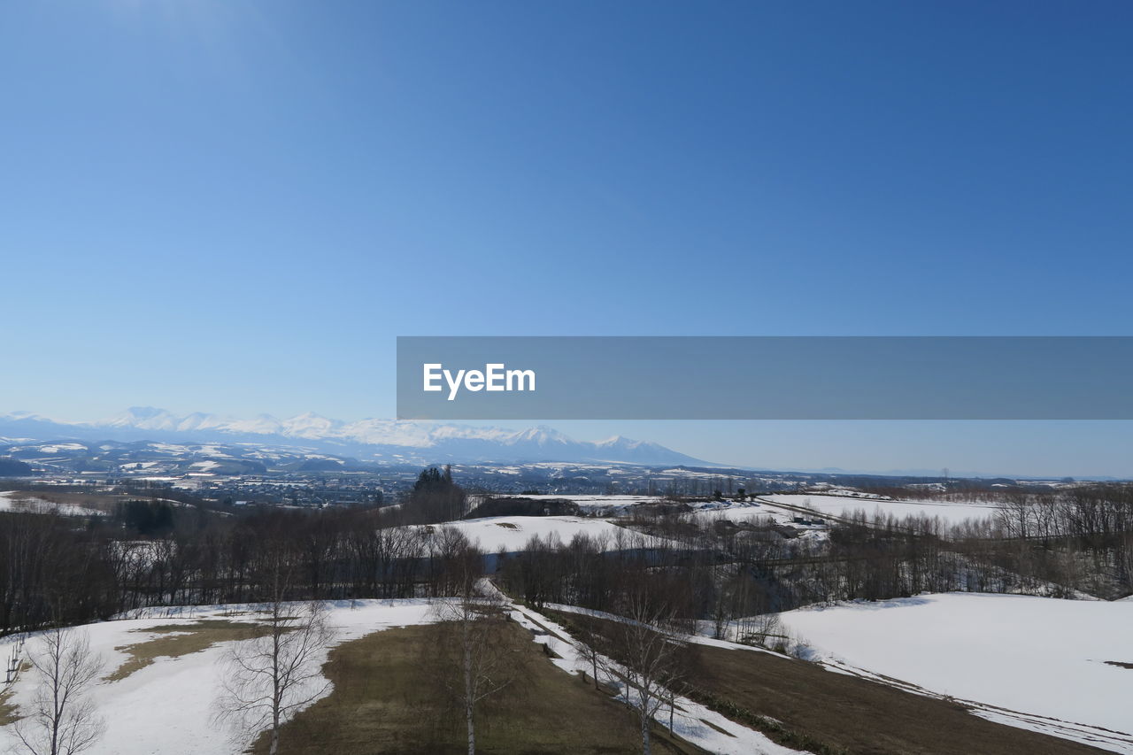 Scenic view of snowcapped mountains against clear blue sky