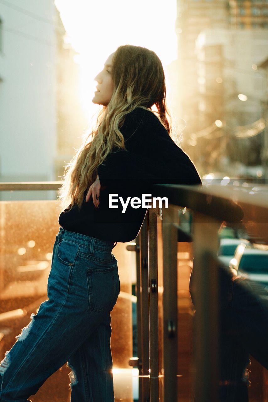 Side view of young woman standing in balcony