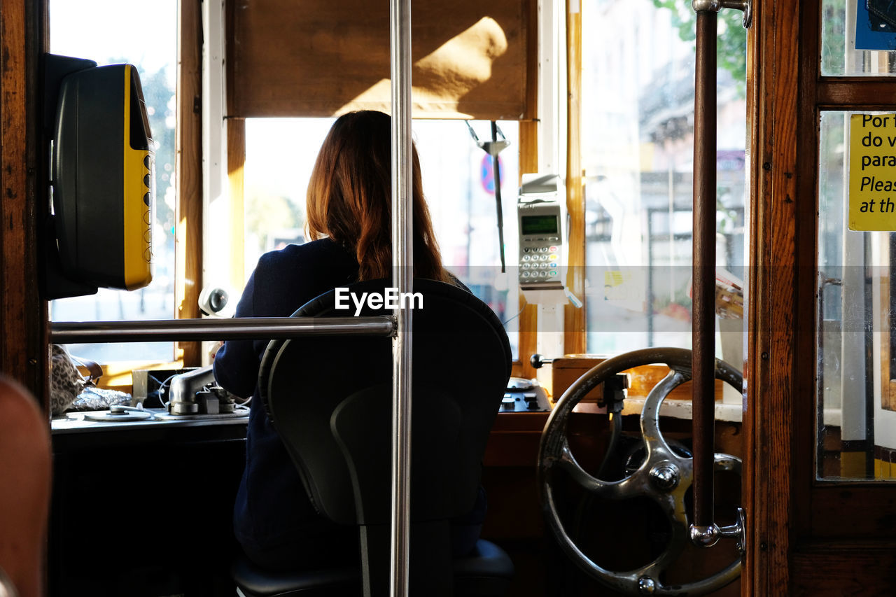 Rear view of woman driving cable car