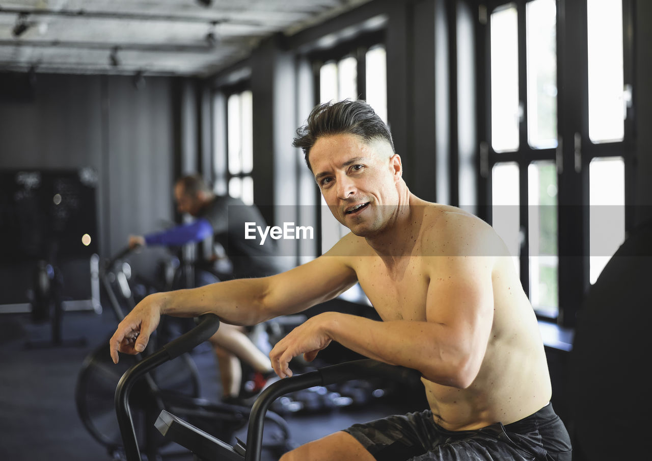 Portrait of shirtless man exercising gym