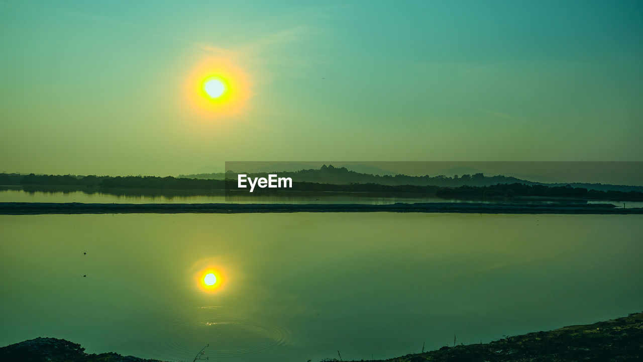 SCENIC VIEW OF LAKE AND MOUNTAINS AGAINST SKY DURING SUNSET