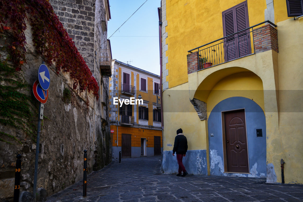 rear view of people walking on street in city