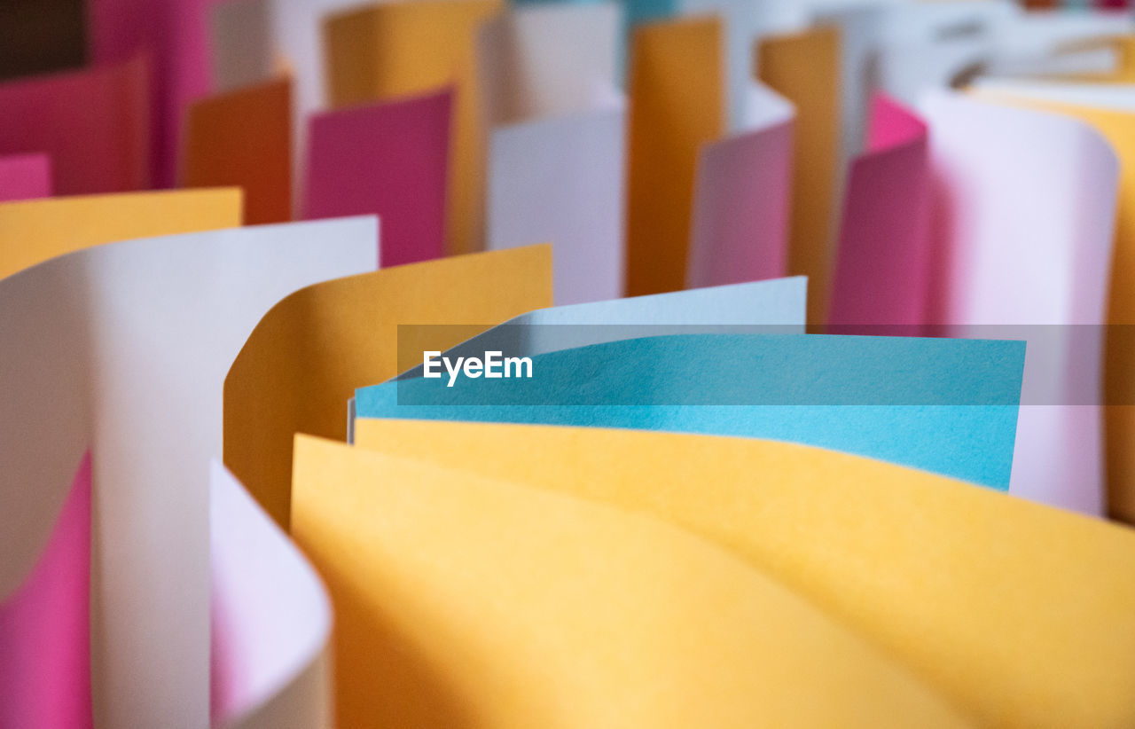 multi colored, yellow, pink, indoors, no people, paper, close-up, business, large group of objects, in a row, selective focus, variation, purple, document, group of objects