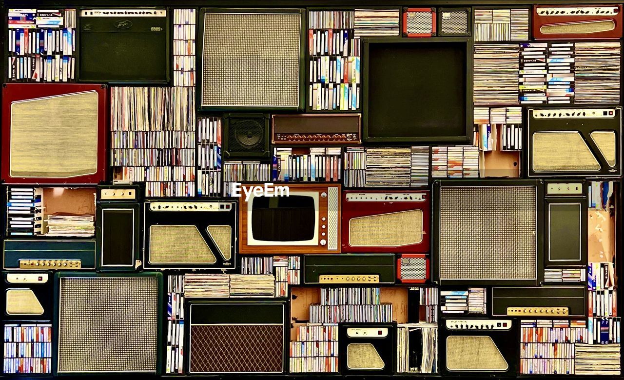 Full frame shot of books, vinil records, tapes, stereos and sound box.