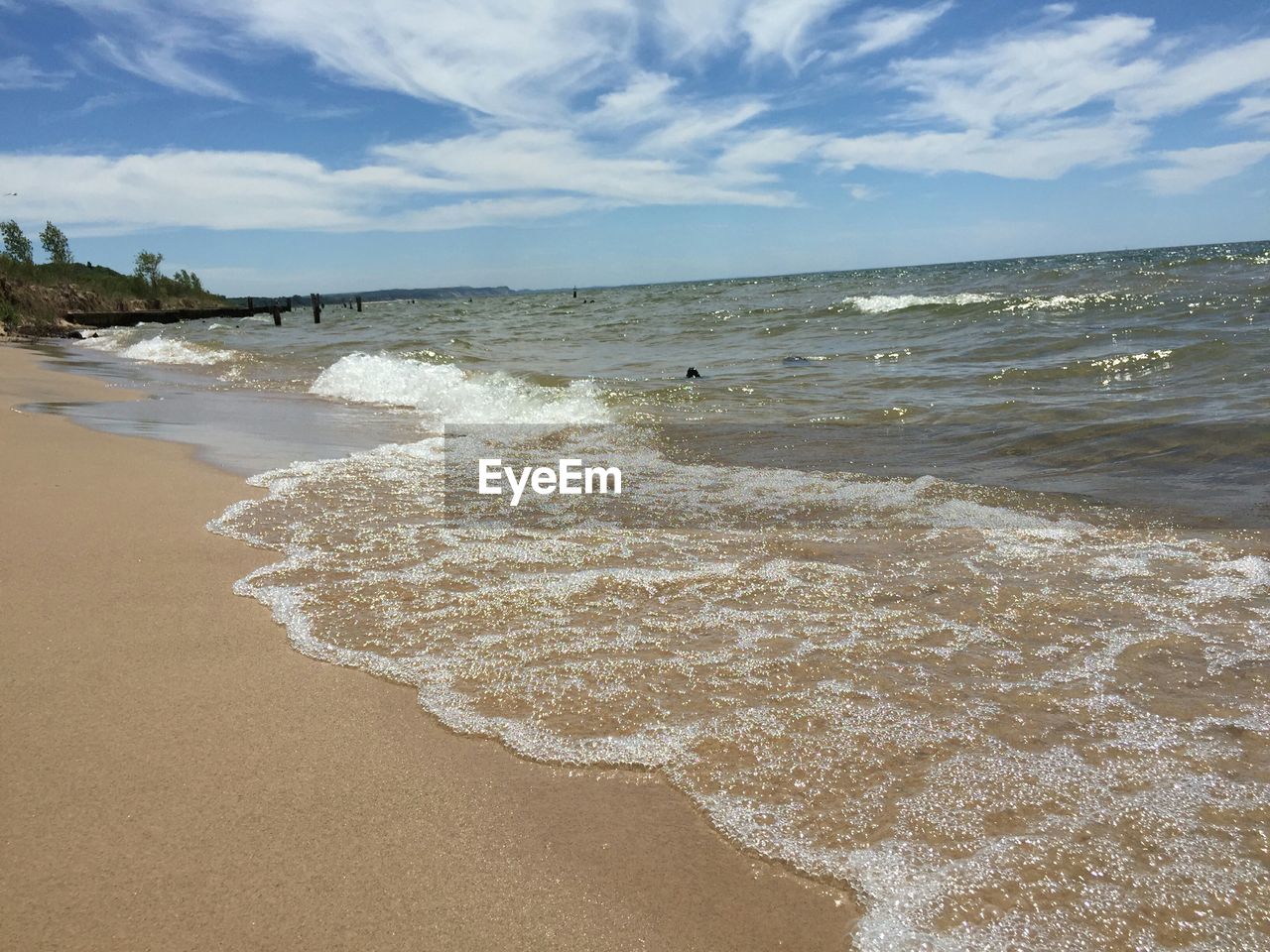 Scenic view of beach against cloudy sky