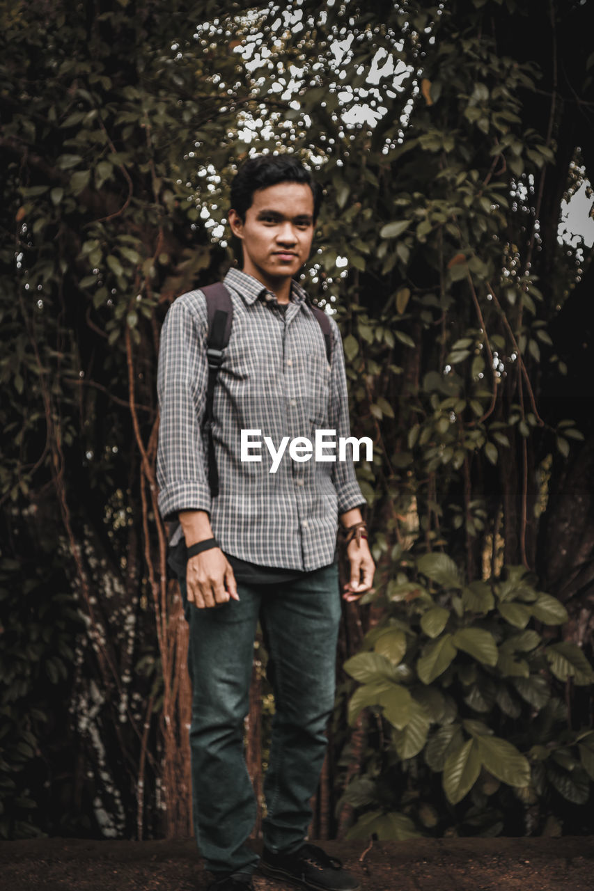 Portrait of man standing in forest