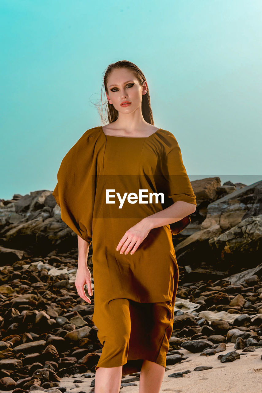 Portrait of young woman standing at beach