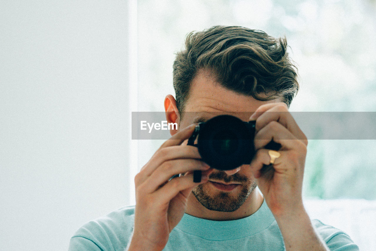 Close-up of man taking picture from camera