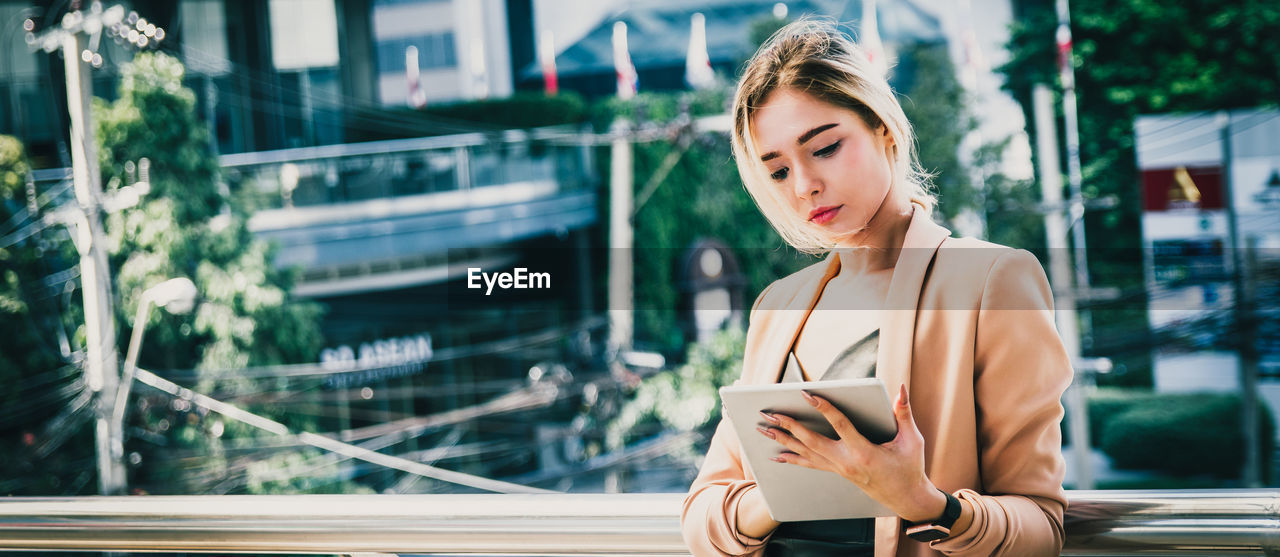 Young woman using digital tablet outdoors