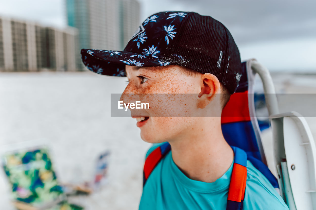 Portrait of boy with freckles looking away wearing a hat