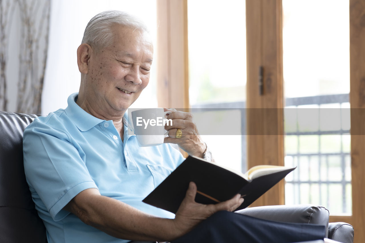 Man holding coffee cup sitting at home