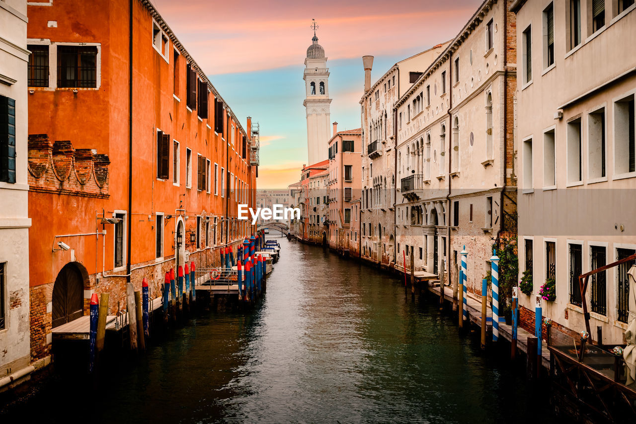 Characteristic canal of venice at sunset with famous crooked bell tower in the background