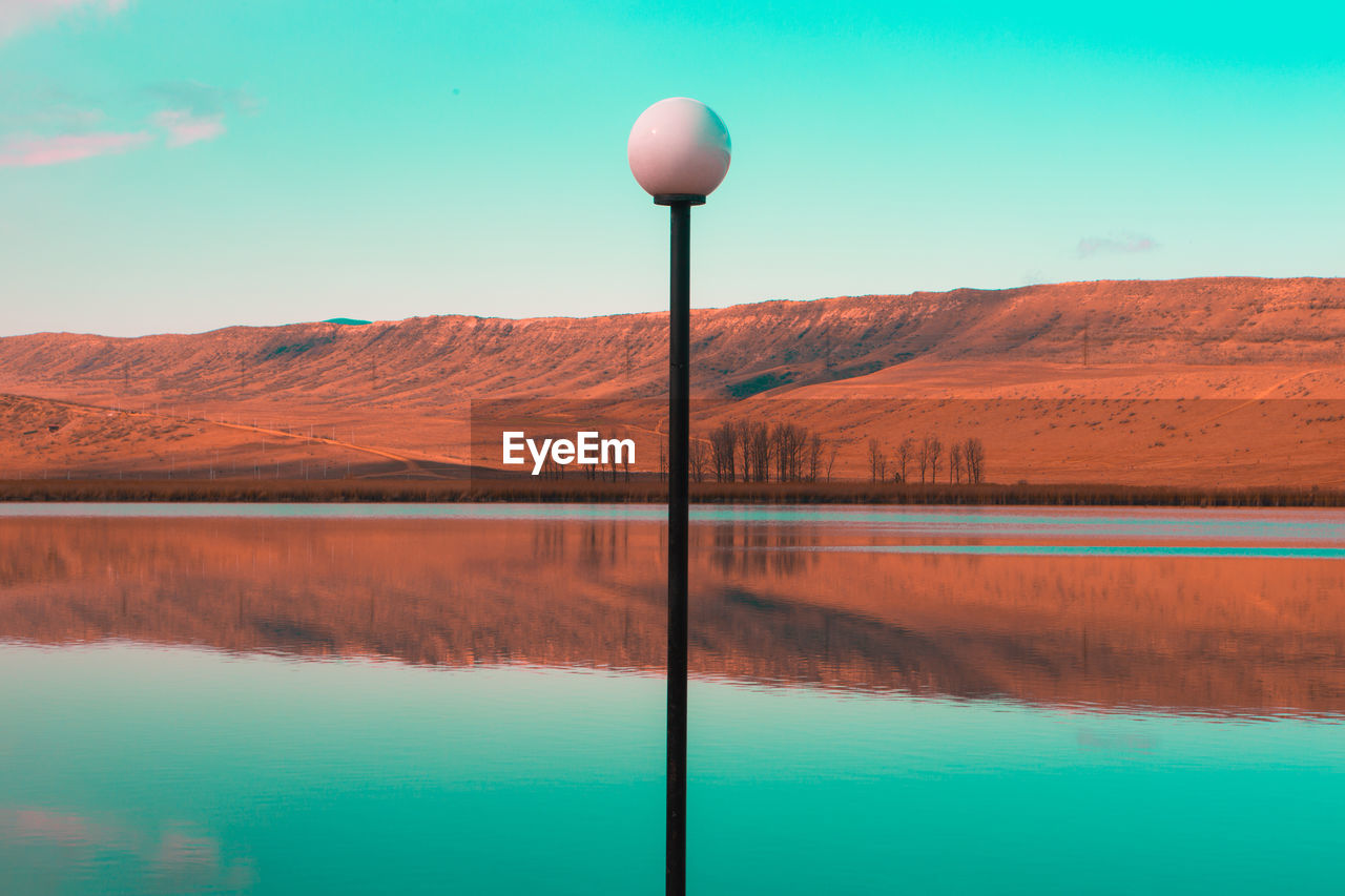 Scenic view of lake by mountains against sky