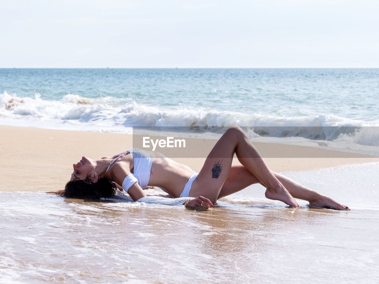 Full length of woman sitting at beach