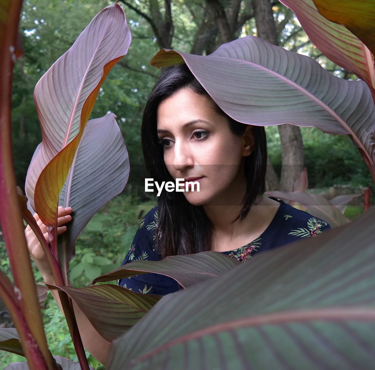 Beautiful young woman by plants