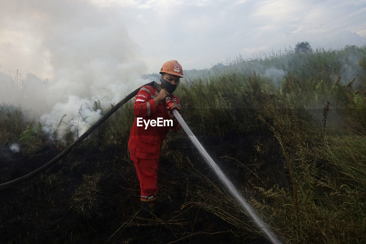 Rear view of firefighter working on field