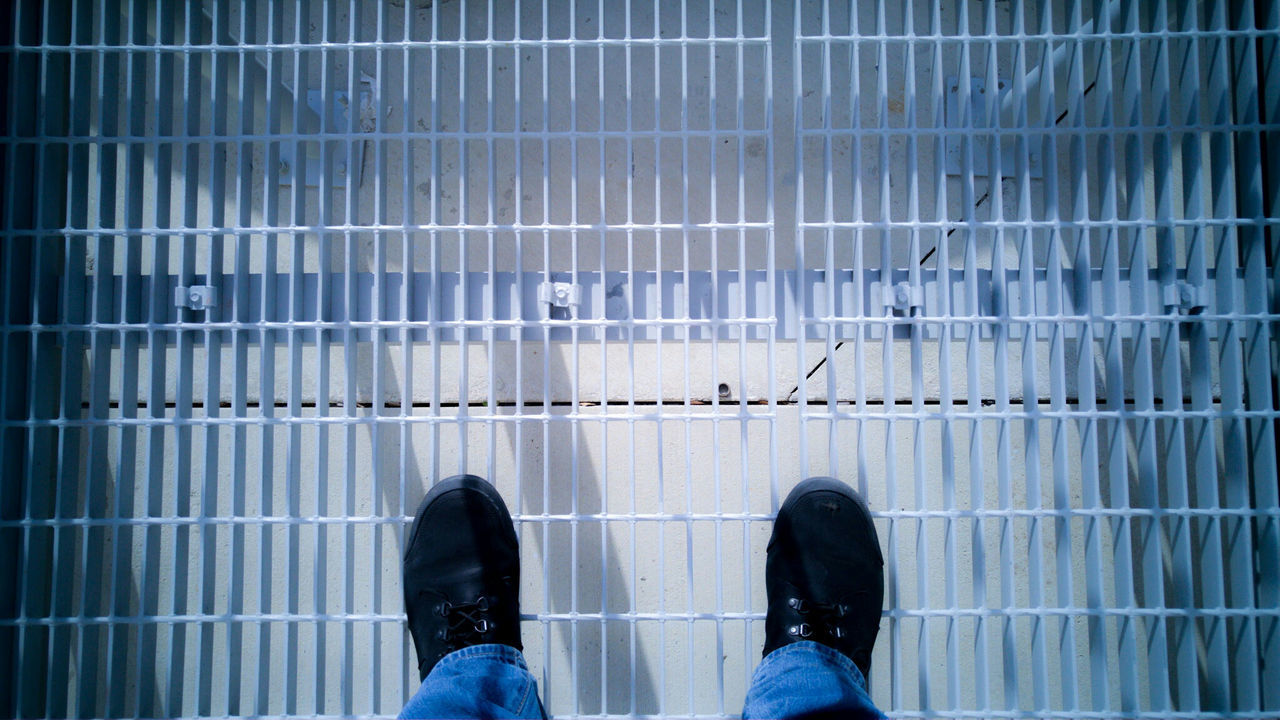 LOW SECTION OF WOMAN STANDING ON TILED FLOOR