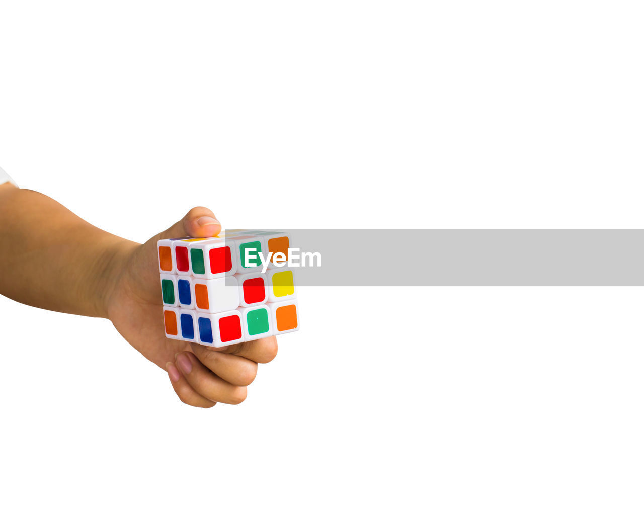 Close-up of woman holding rubik cube against white background
