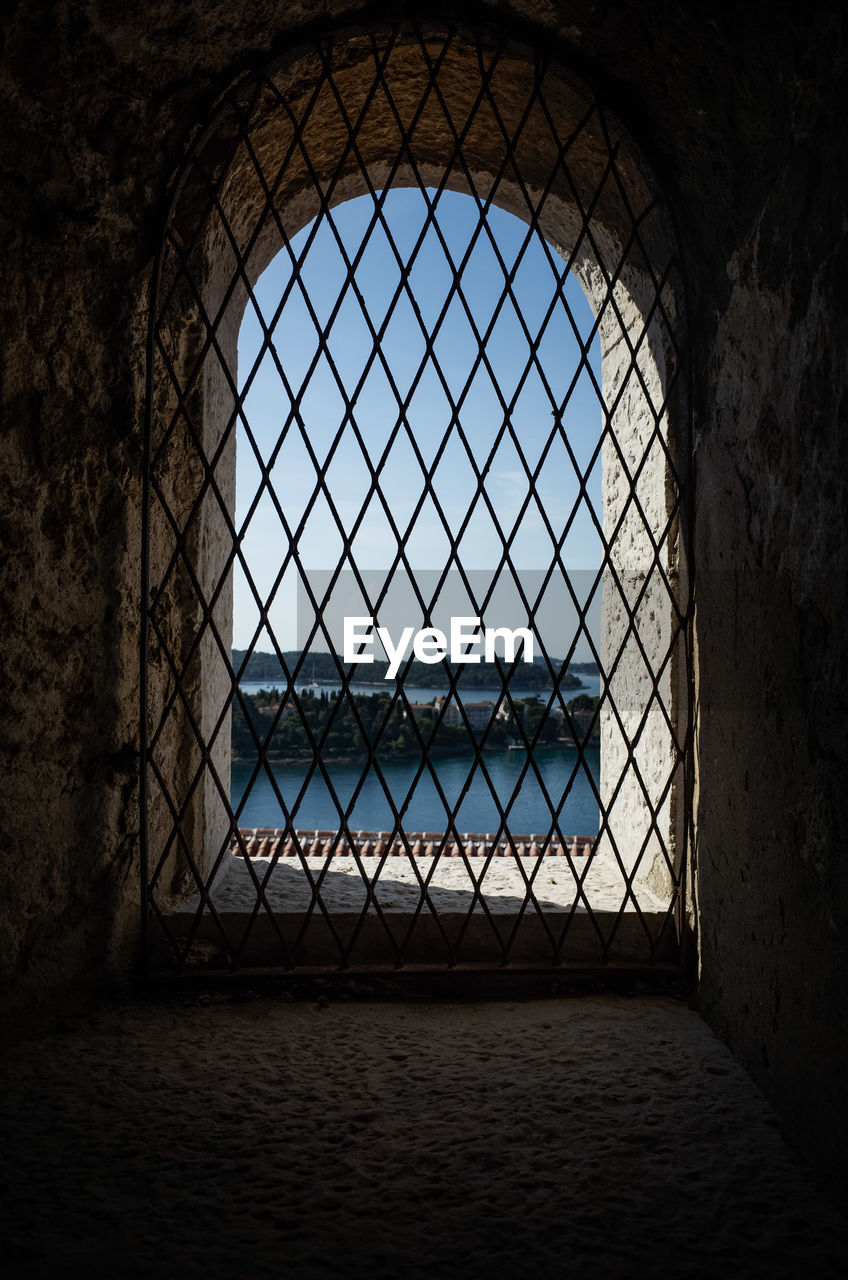 darkness, light, architecture, built structure, window, no people, indoors, building, history, day, arch, the past, black, prison, pattern, metal, nature, gate, lighting, dark, wall - building feature, security, sky