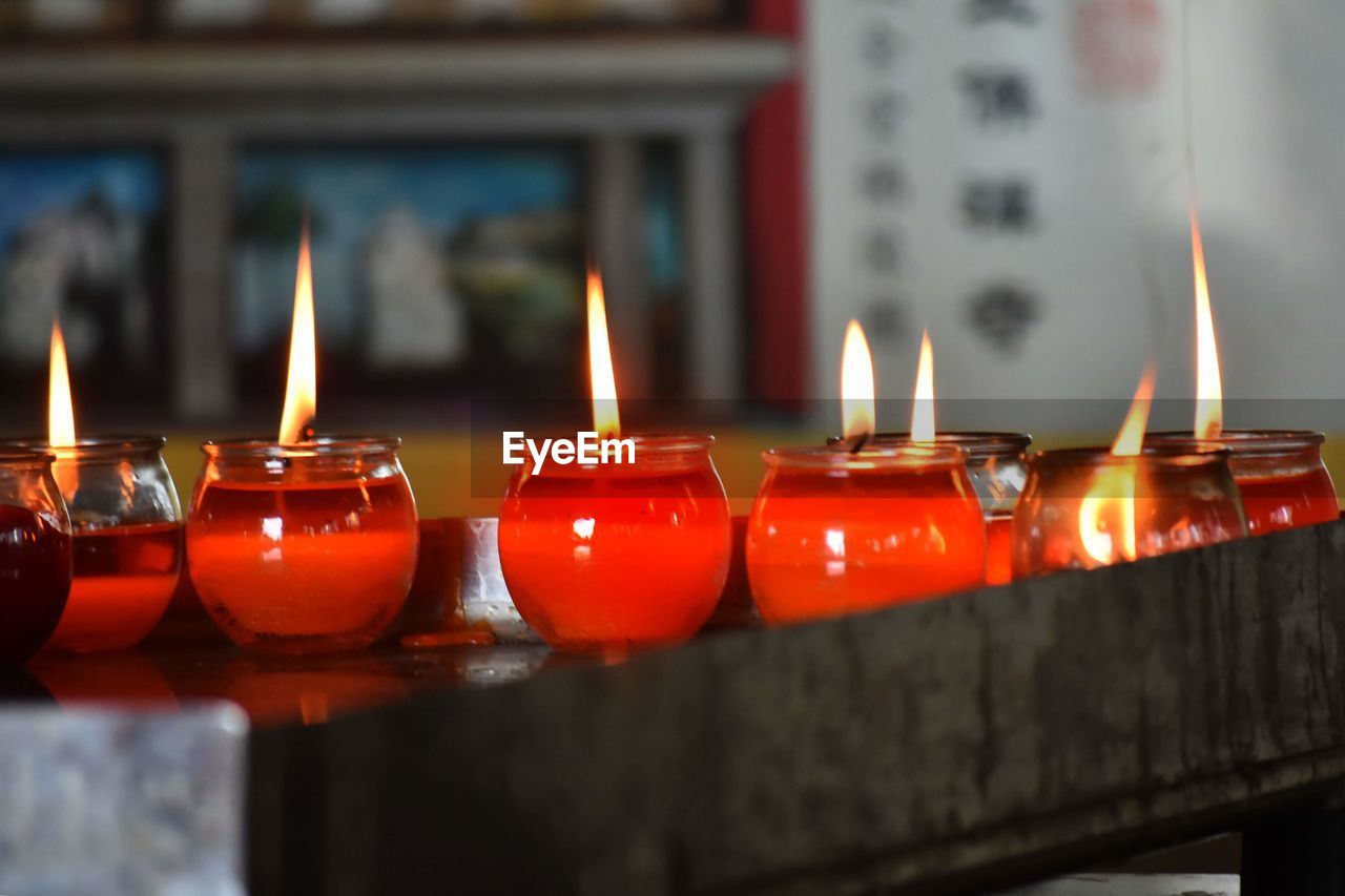 Close-up of illuminated candles on table