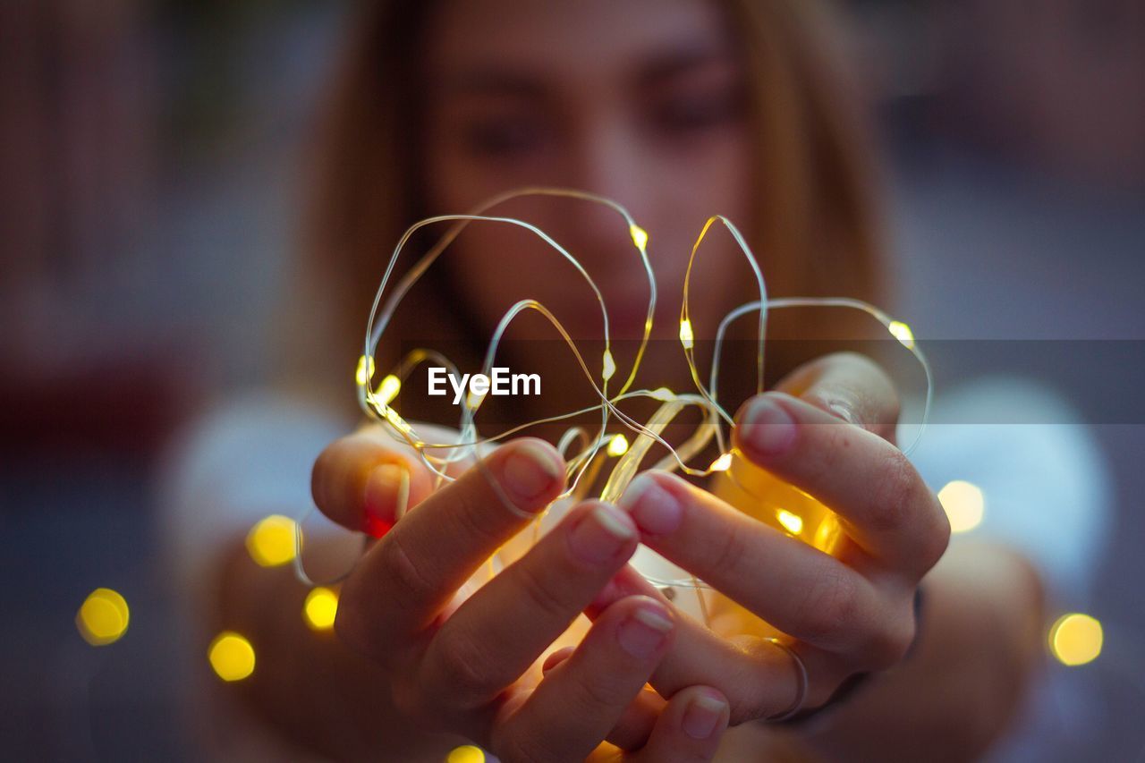 Close-up of hand holding christmas lights