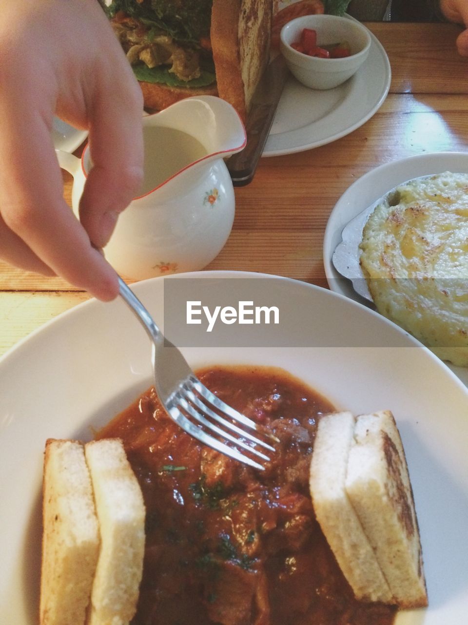 Cropped hand reaching for food served in plate