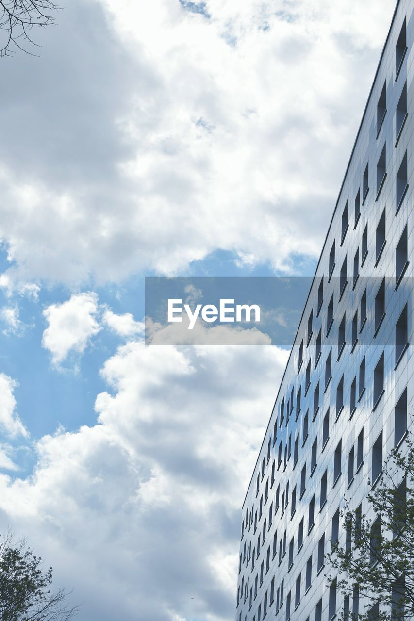 LOW ANGLE VIEW OF MODERN BUILDINGS AGAINST CLOUDY SKY