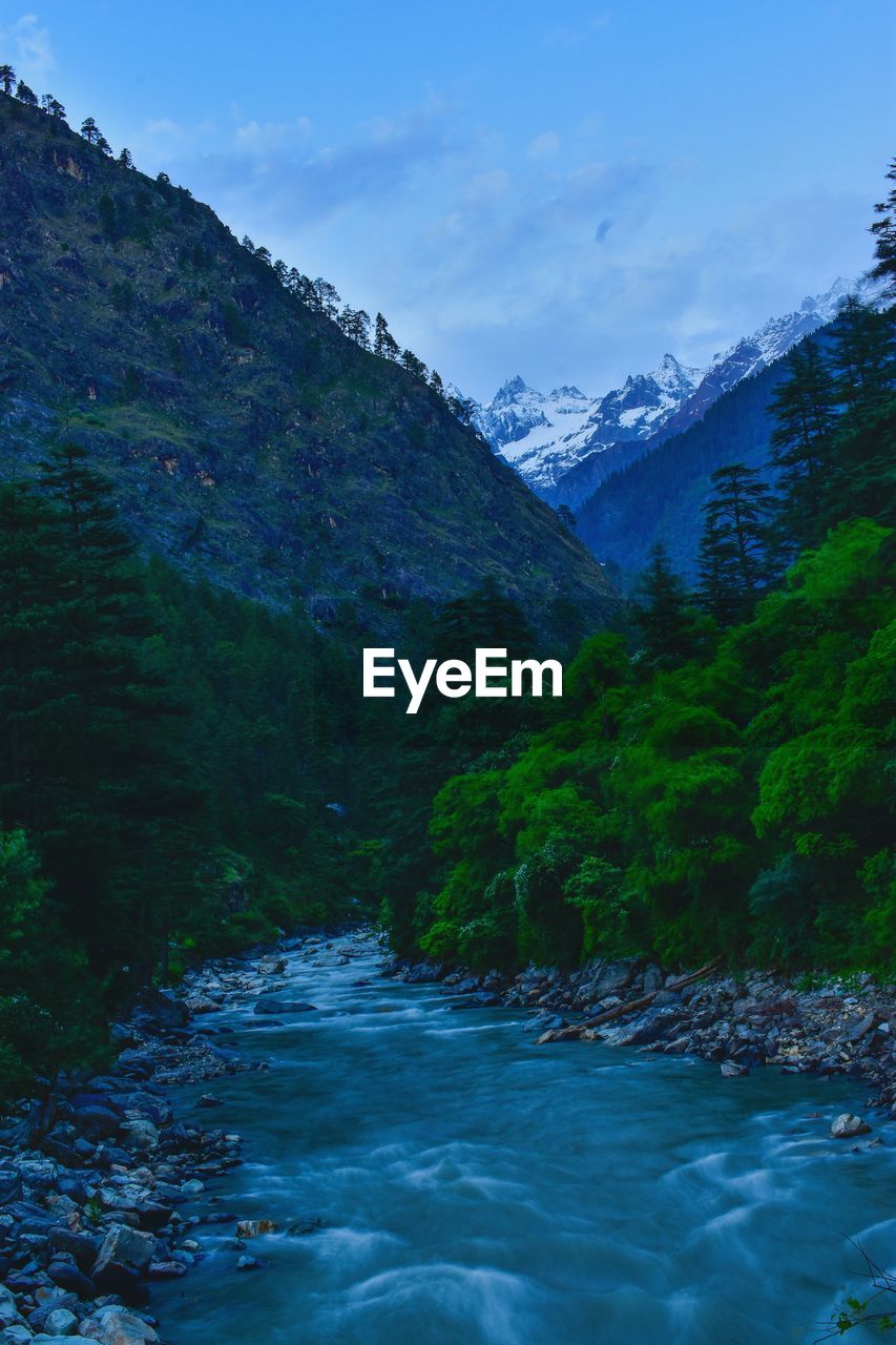 Scenic view of river amidst mountains against sky