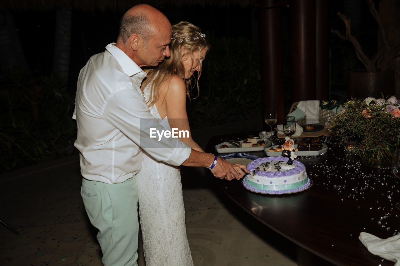 COUPLE STANDING BY TABLE