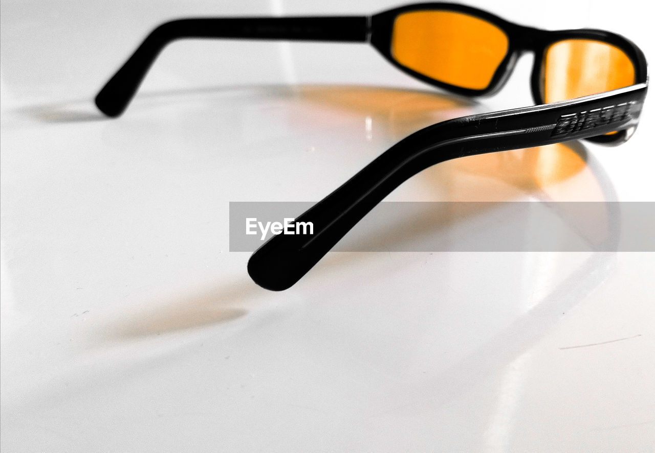 CLOSE-UP OF EYEGLASSES ON WHITE TABLE