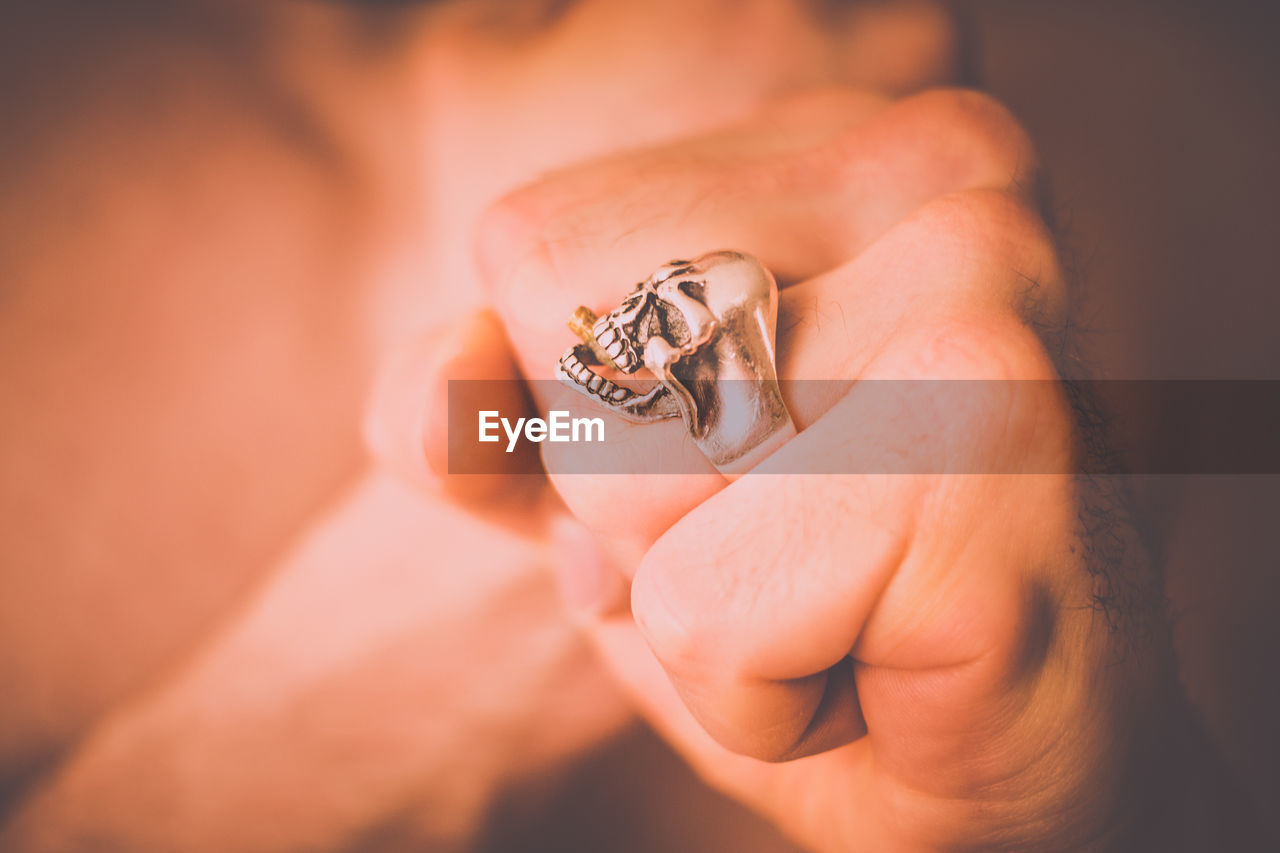 Close-up of person wearing skull ring