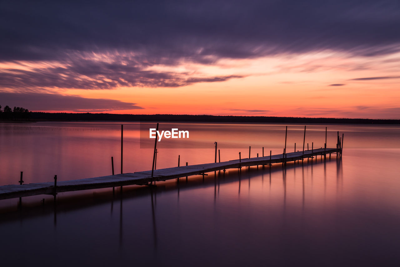 pier over lake against sky during sunset